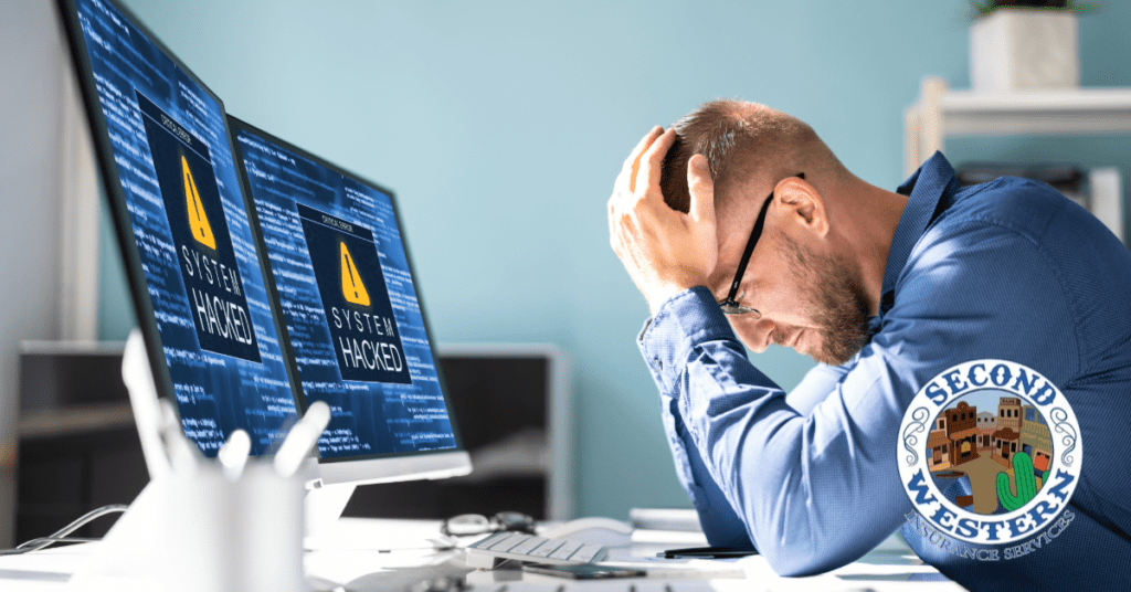 A frustrated man holds his head in his hands while sitting in front of two computer monitors displaying a "SYSTEM HACKED" warning. The logo of Second Western Insurance Services is visible in the bottom right corner.